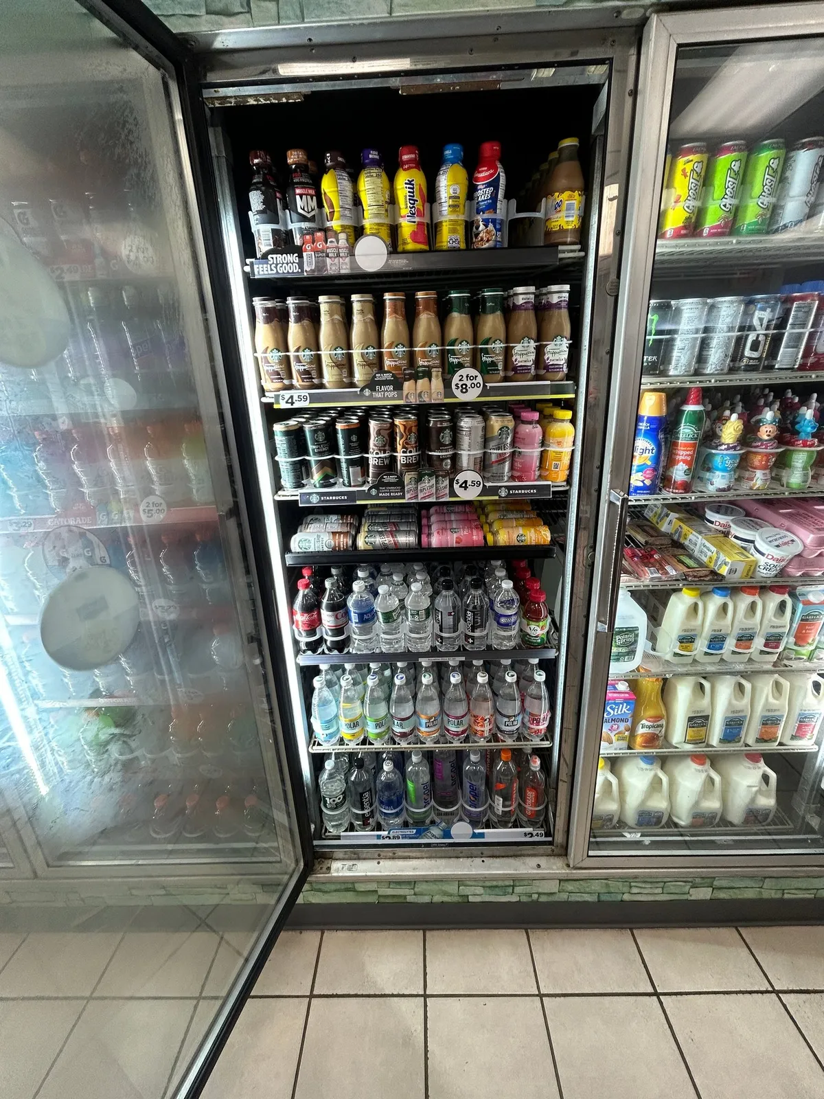 A convenience store cooler door with can rollers fitted on the shelves