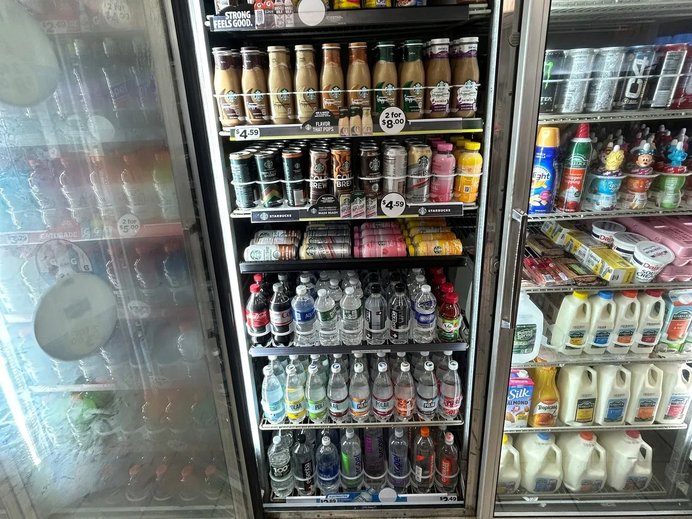 A convenience store cooler door with can rollers fitted on the shelves