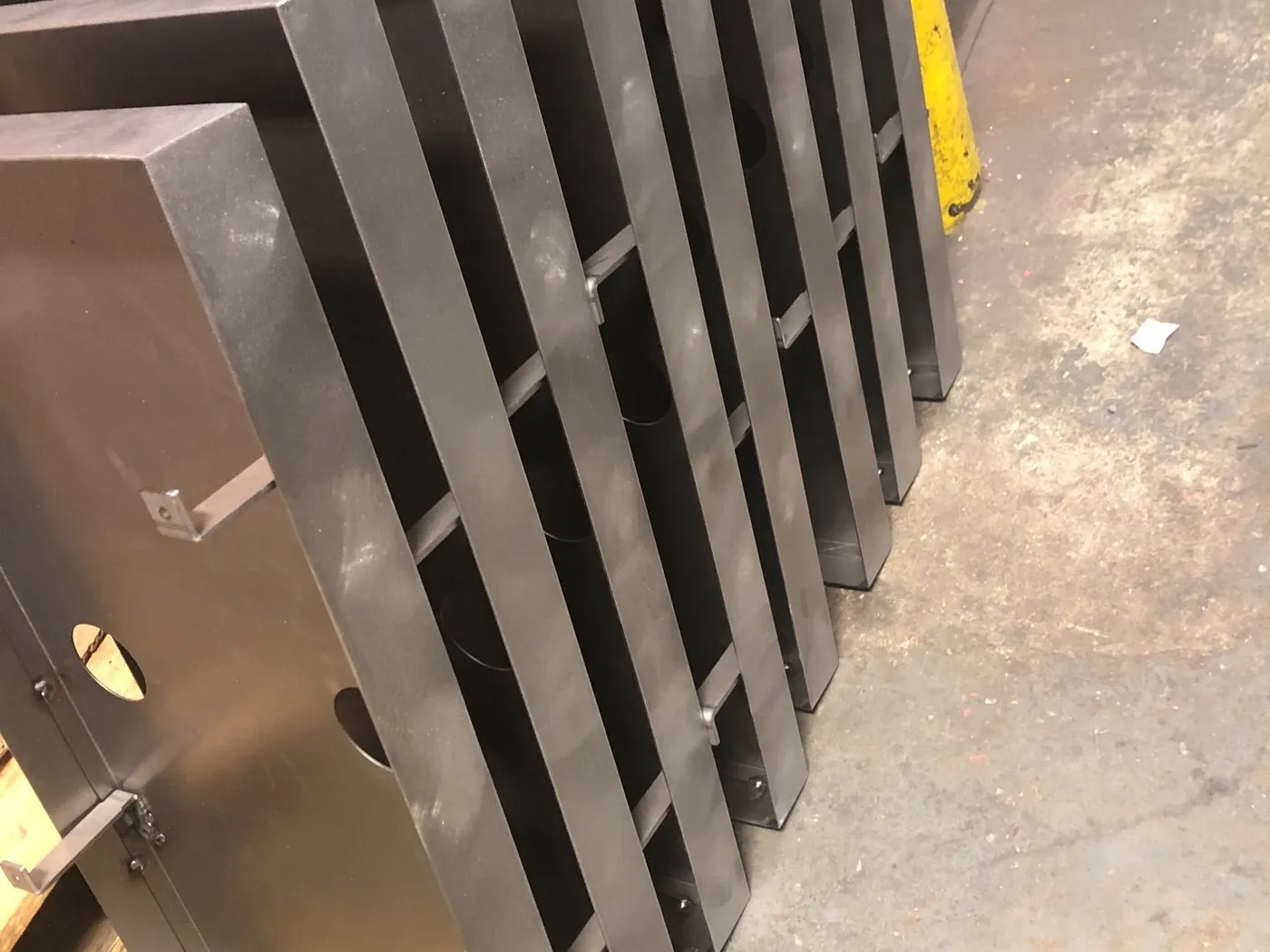 Stack of black formed steel parts on a pallet