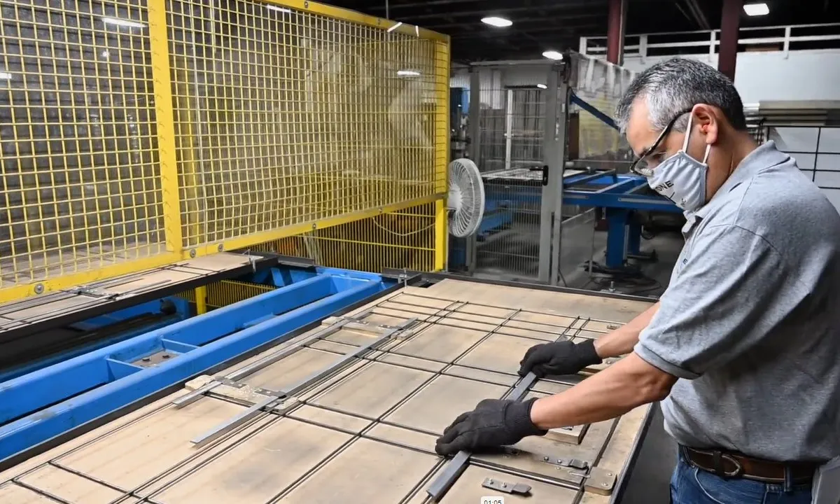 Operator welding a wire grid on a yellow fixture