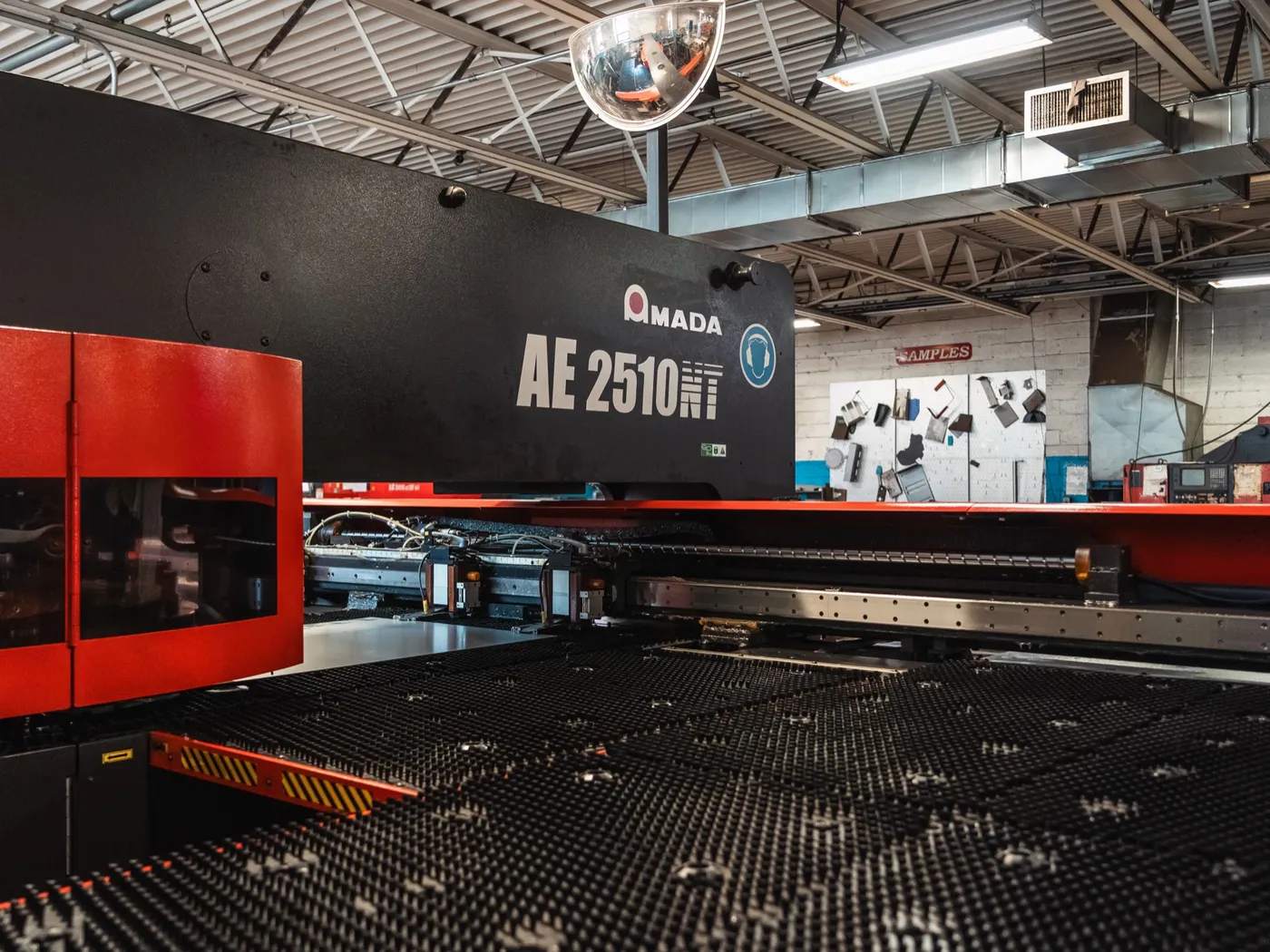 Amada AE 2510NT turret punch, wide view against a dark wall
